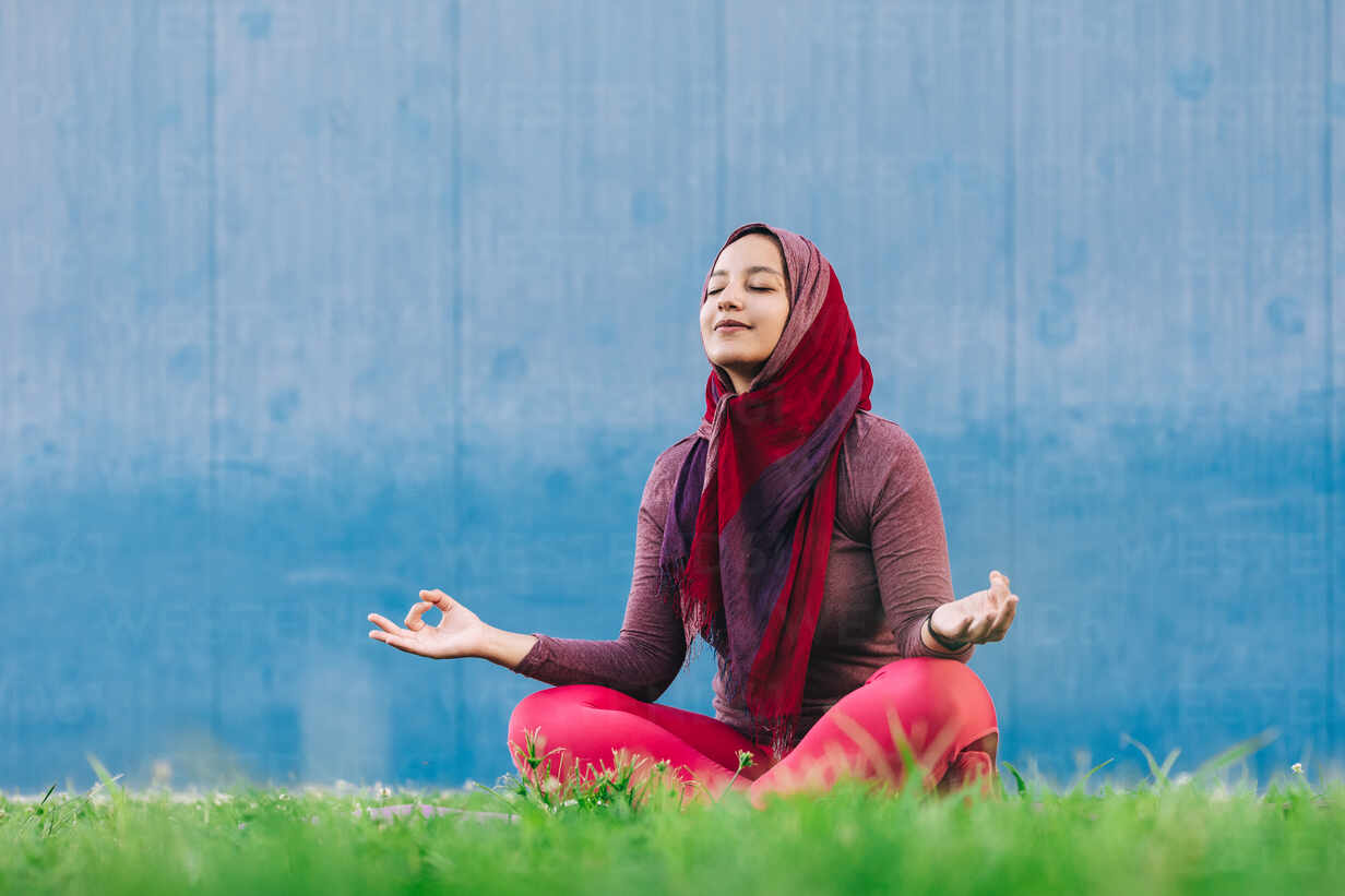 Muslim woman meditating in Lotus pose